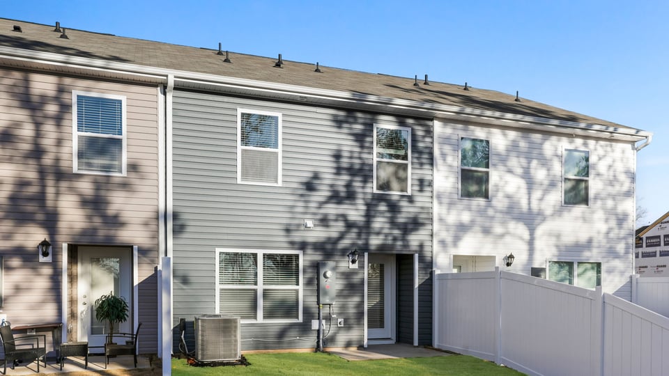 Back exterior of home with large backyard.