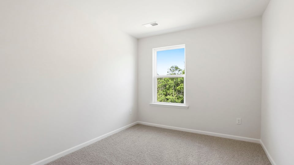 Bedroom with carpet and window.