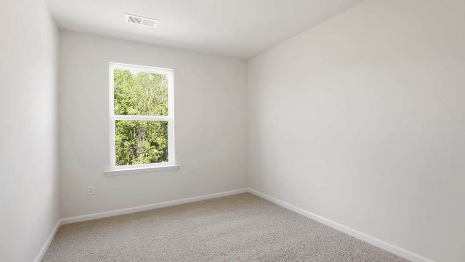 Bedroom with carpet and window.
