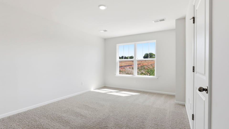 Bedroom with carpet and window.