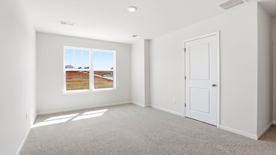 Bedroom with carpet and window.