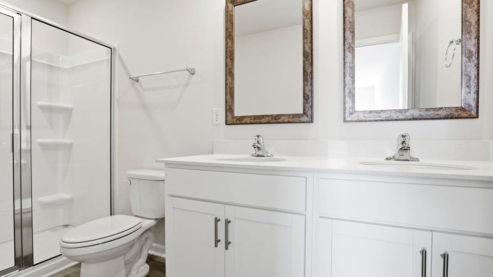 Bathroom with double vanity and walk in shower.