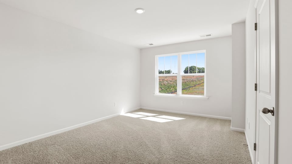 Bedroom with carpet and window.
