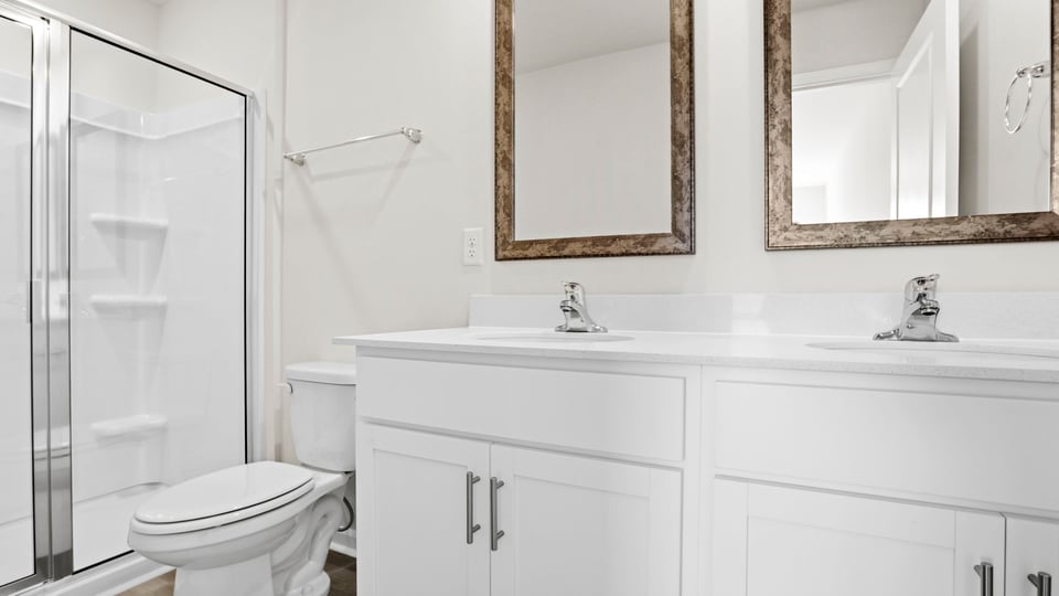 Bathroom with double vanity and walk in shower.