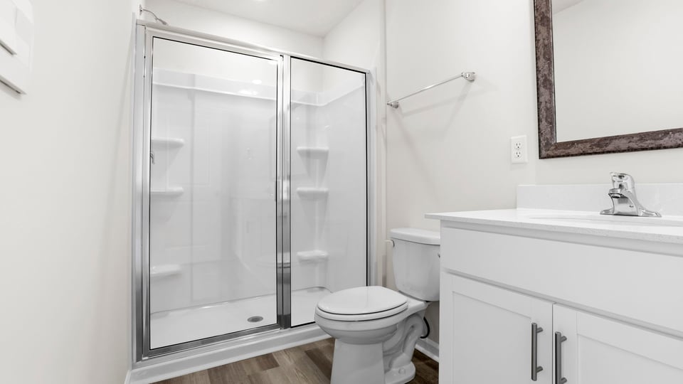 Bathroom with double vanity and walk in shower.