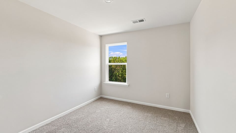 Bedroom with carpet and window.