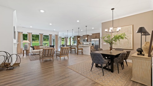 Living area with view of kitchen and windows.