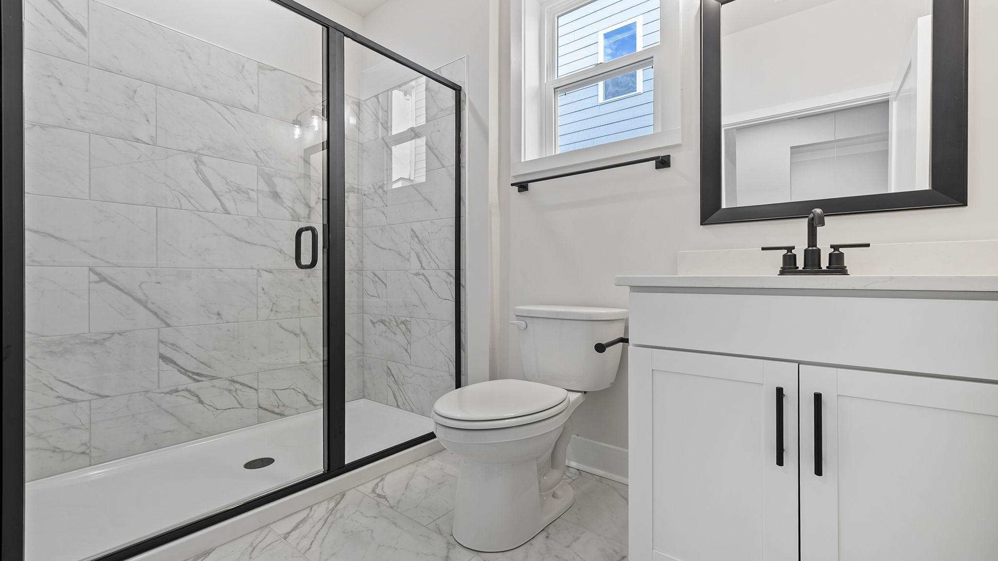 Hall bathroom with walk-in shower and vanity.