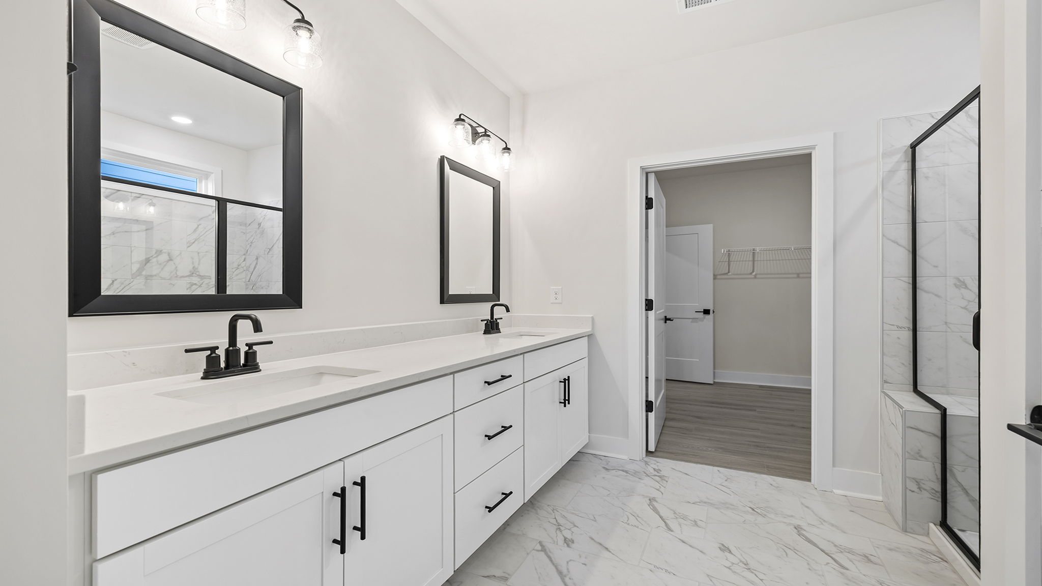 Primary bathroom with dual sink vanity and walk-in shower.