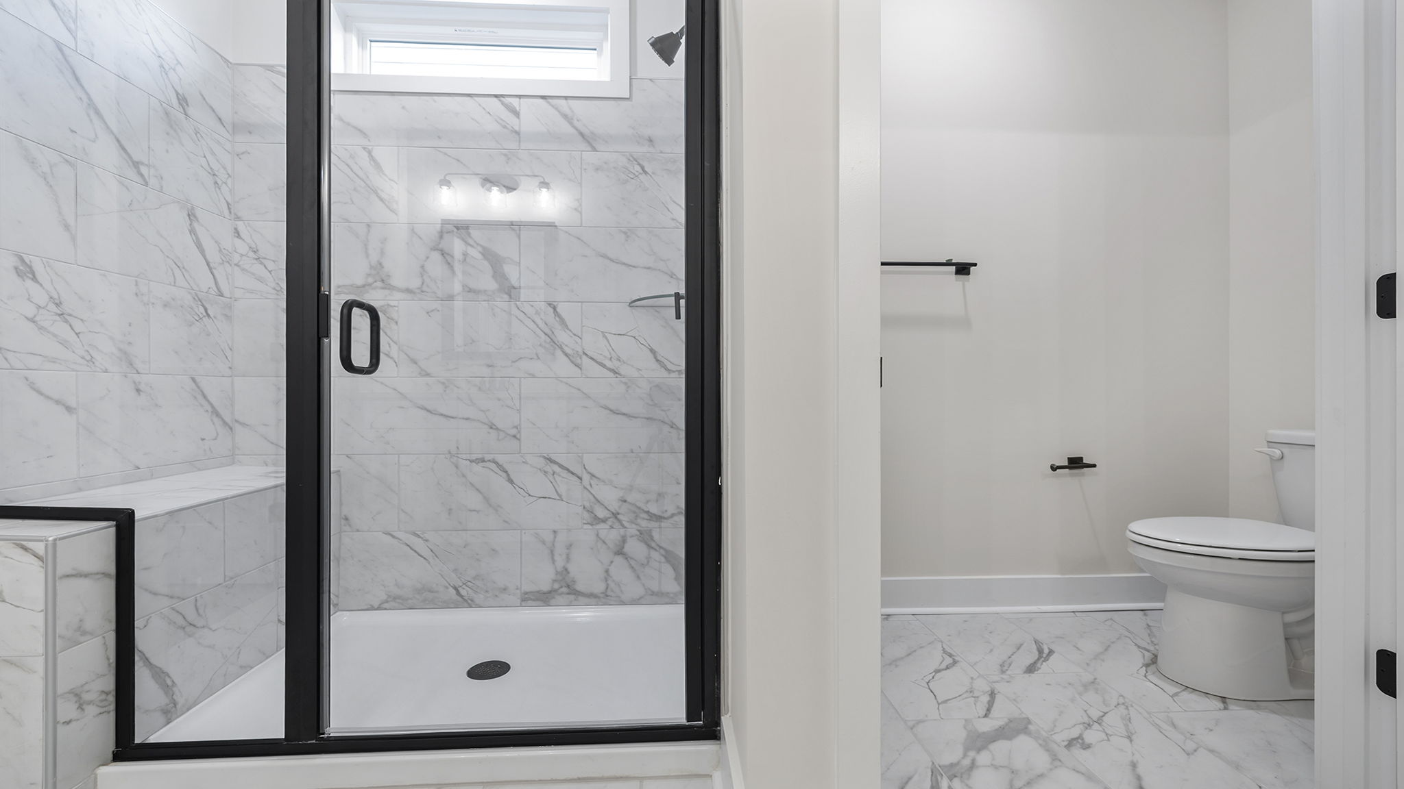 Primary bathroom with walk-in shower and toilet area.