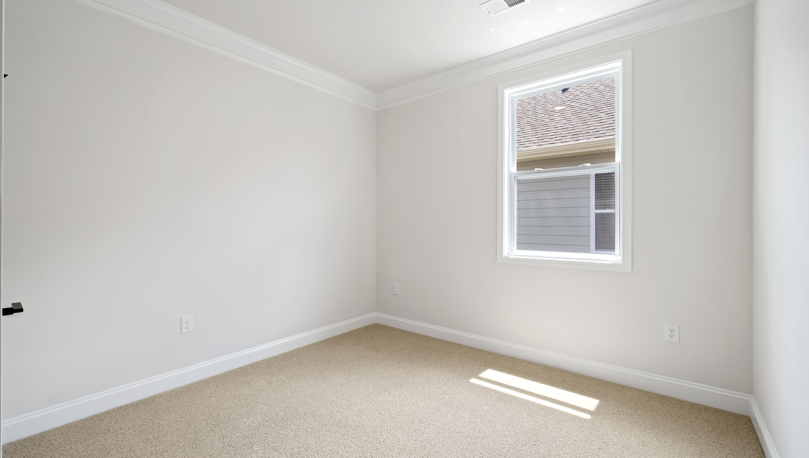 Bedroom with large window and carpet.