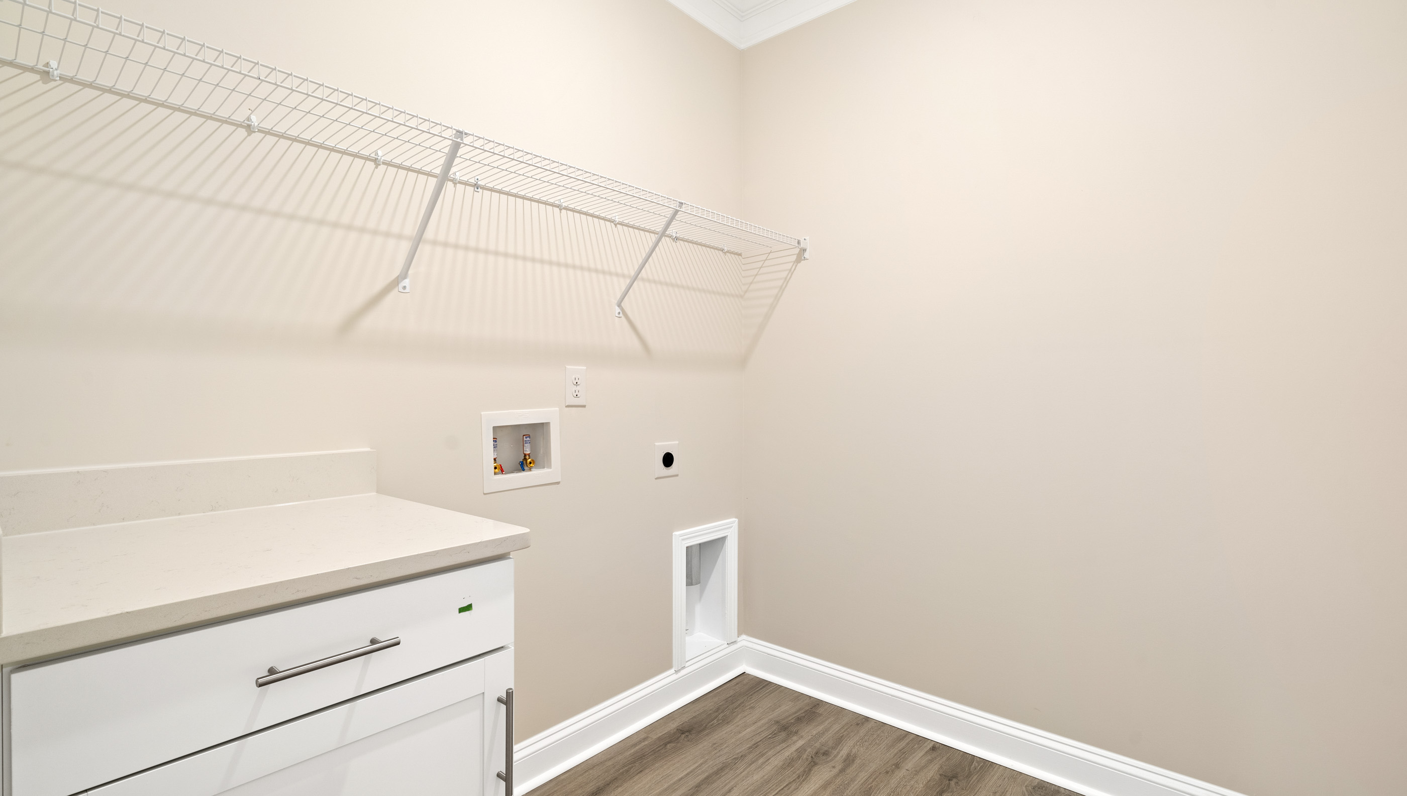Laundry room with hanging storage racks.