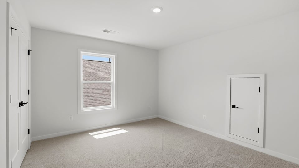 Bedroom with carpet and window.a