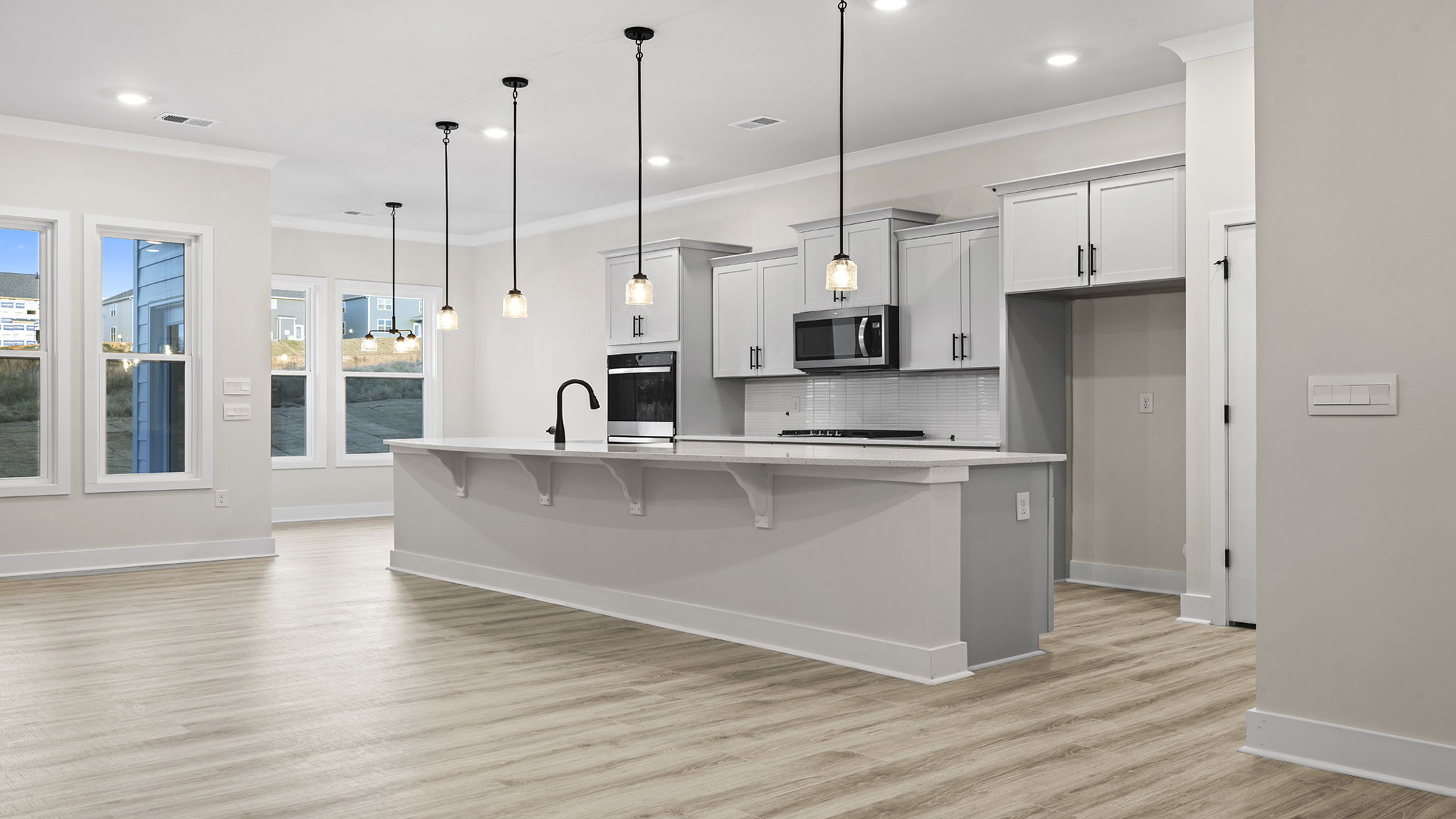 Kitchen and island hosts quartz countertops.