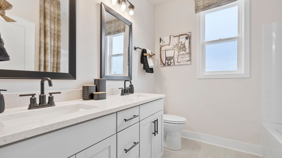 Bathroom with double vanity sink and tub.