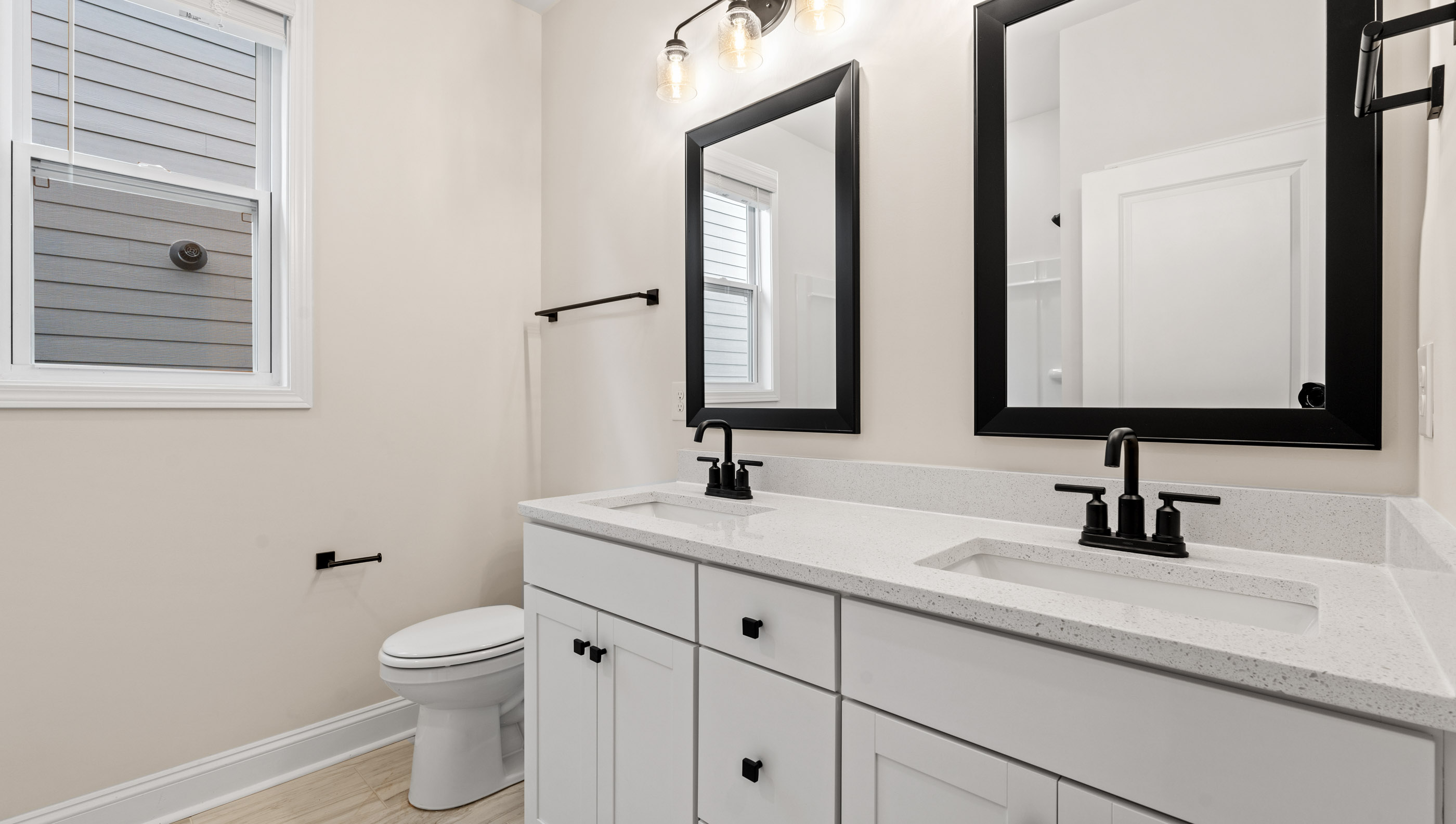 Bathroom with double vanity sink and toilet.