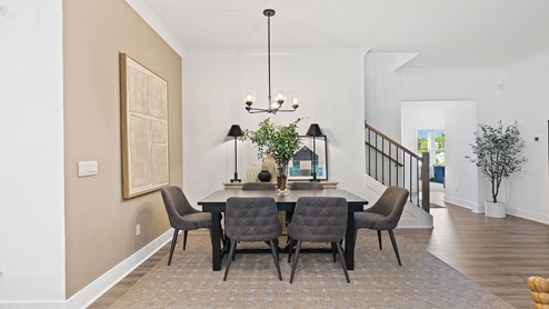 Formal dining area with view of stairs.