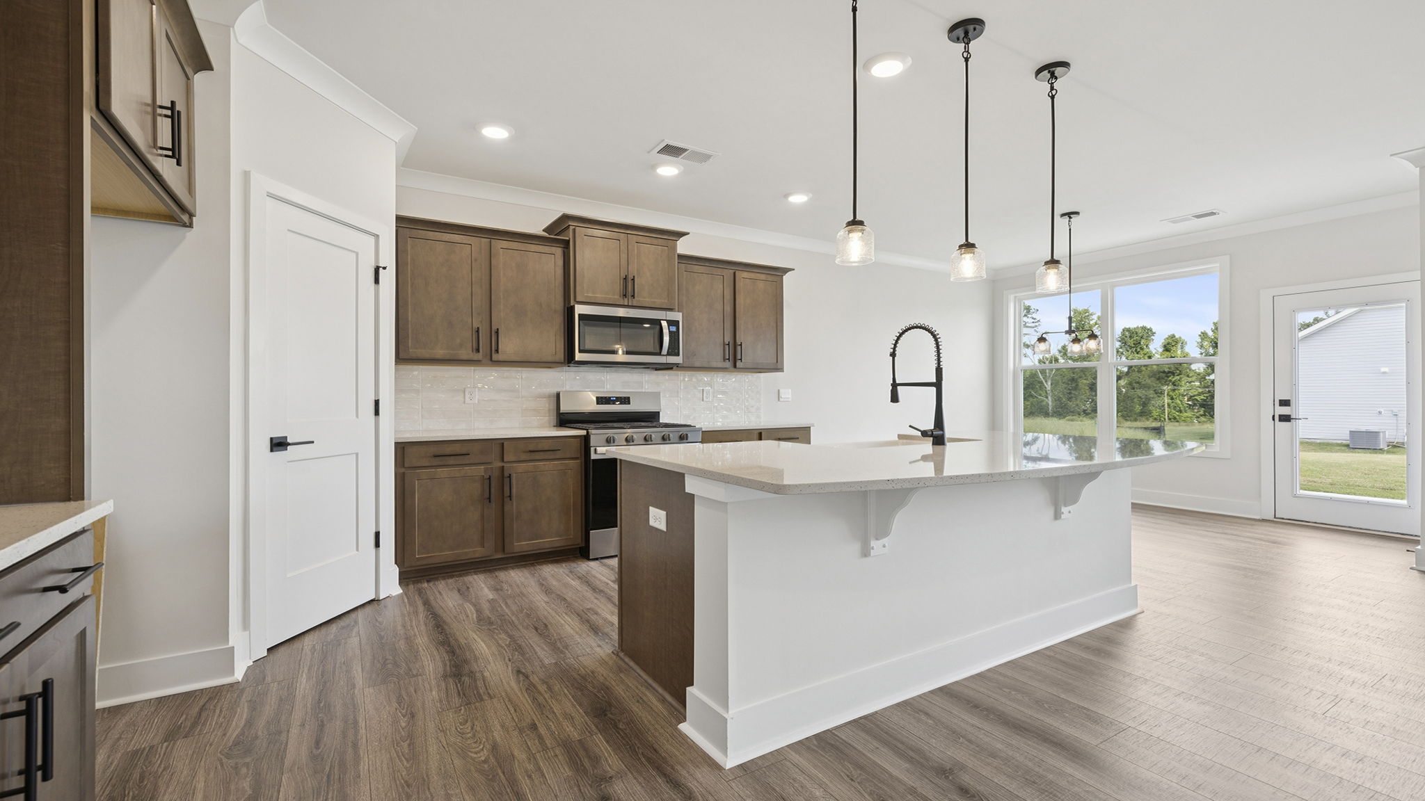 View of kitchen with pendulum lighting.