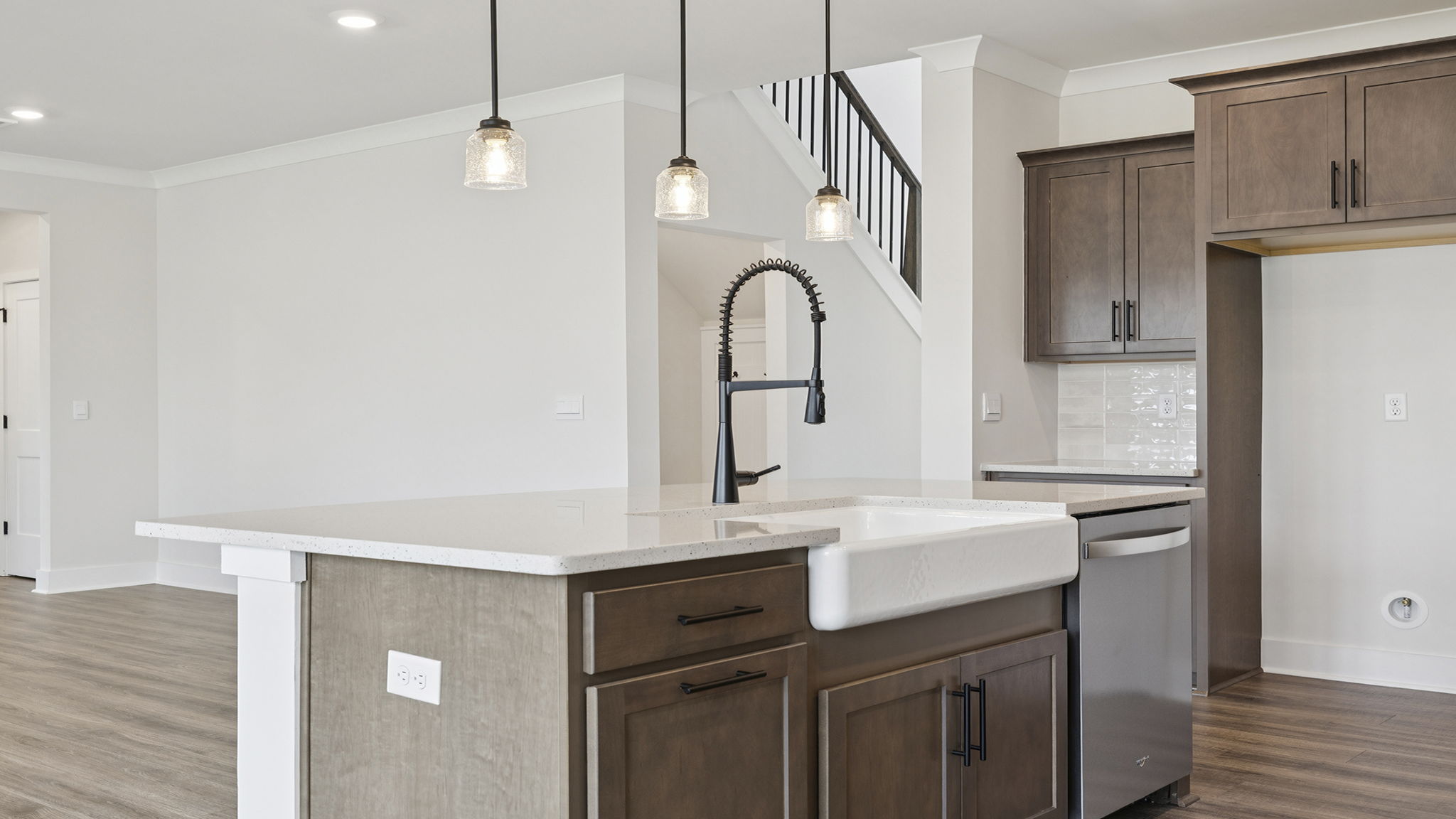 View of kitchen island with pendulum lighting.