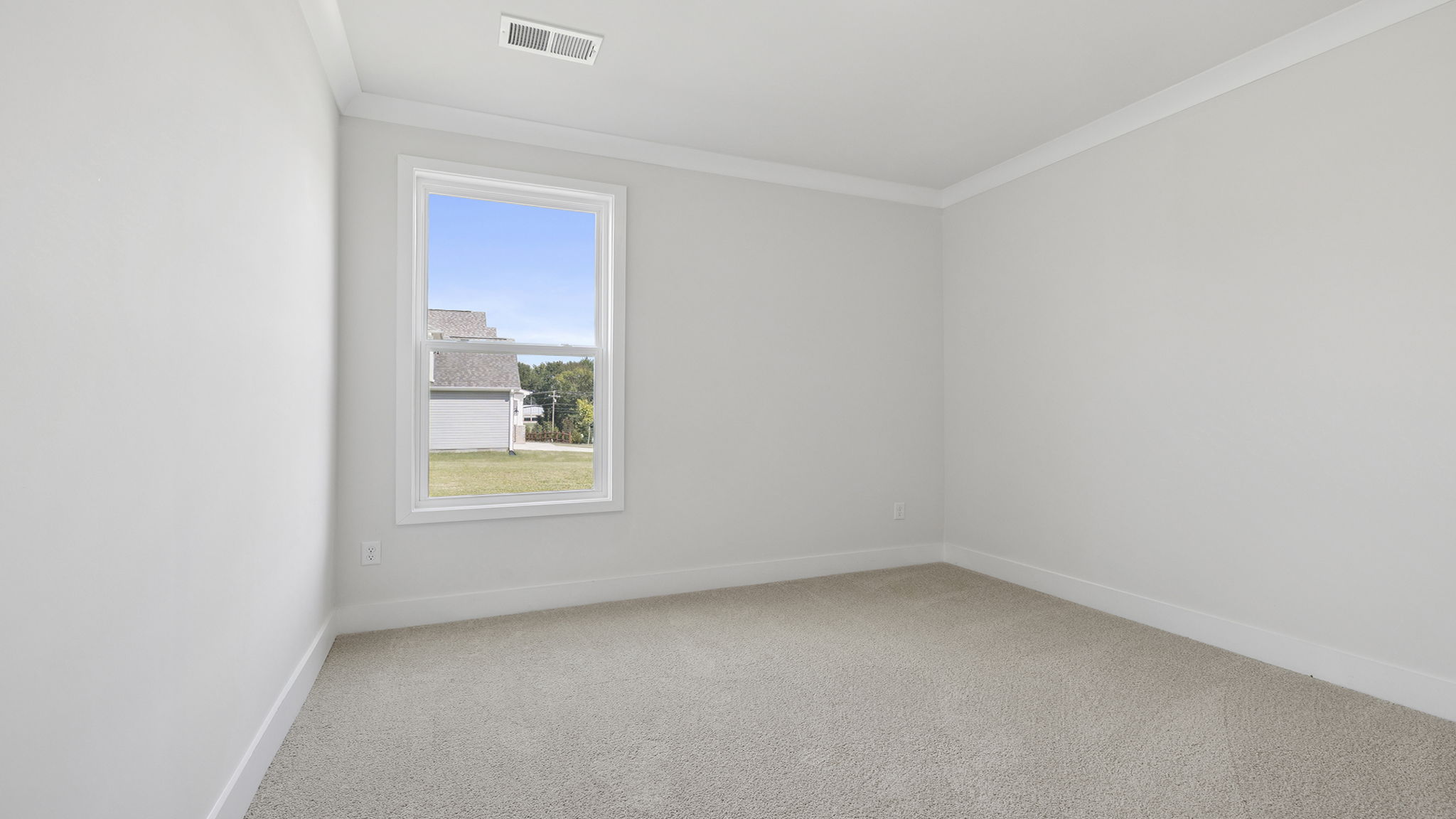 Main floor bedroom with window and carpet.