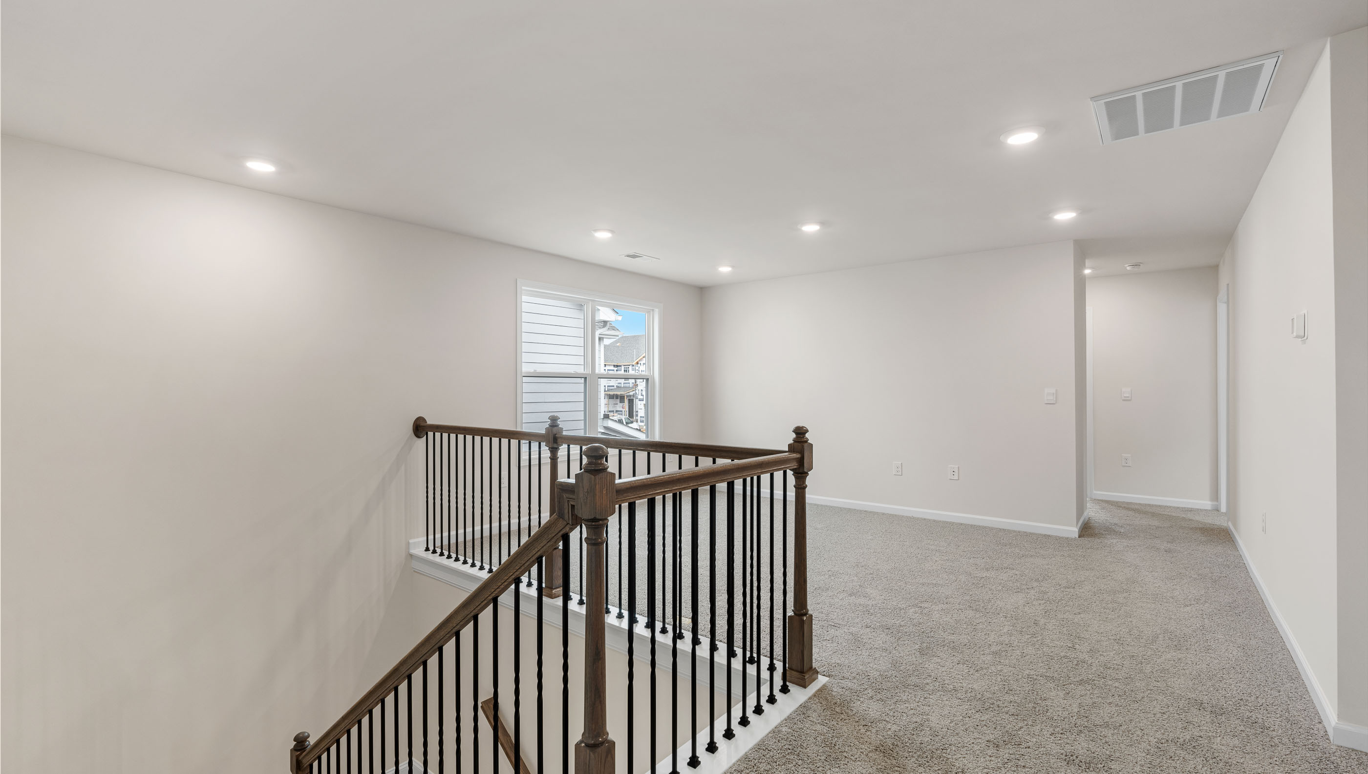 Loft area with carpet and windows.