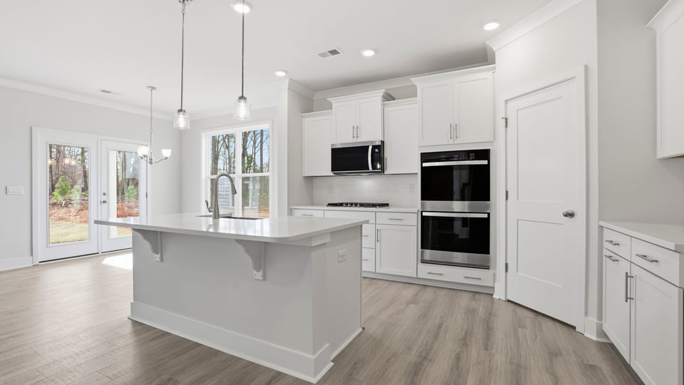Large kitchen with island and quartz countertops.