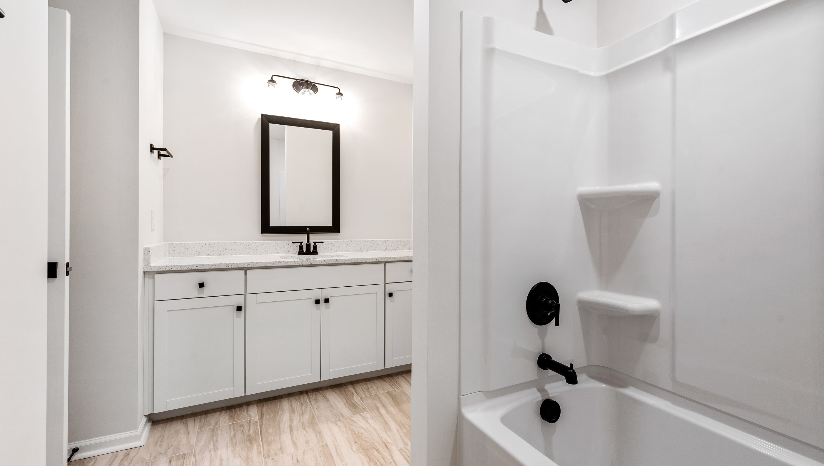 Bathroom with double vanity sink and tub.