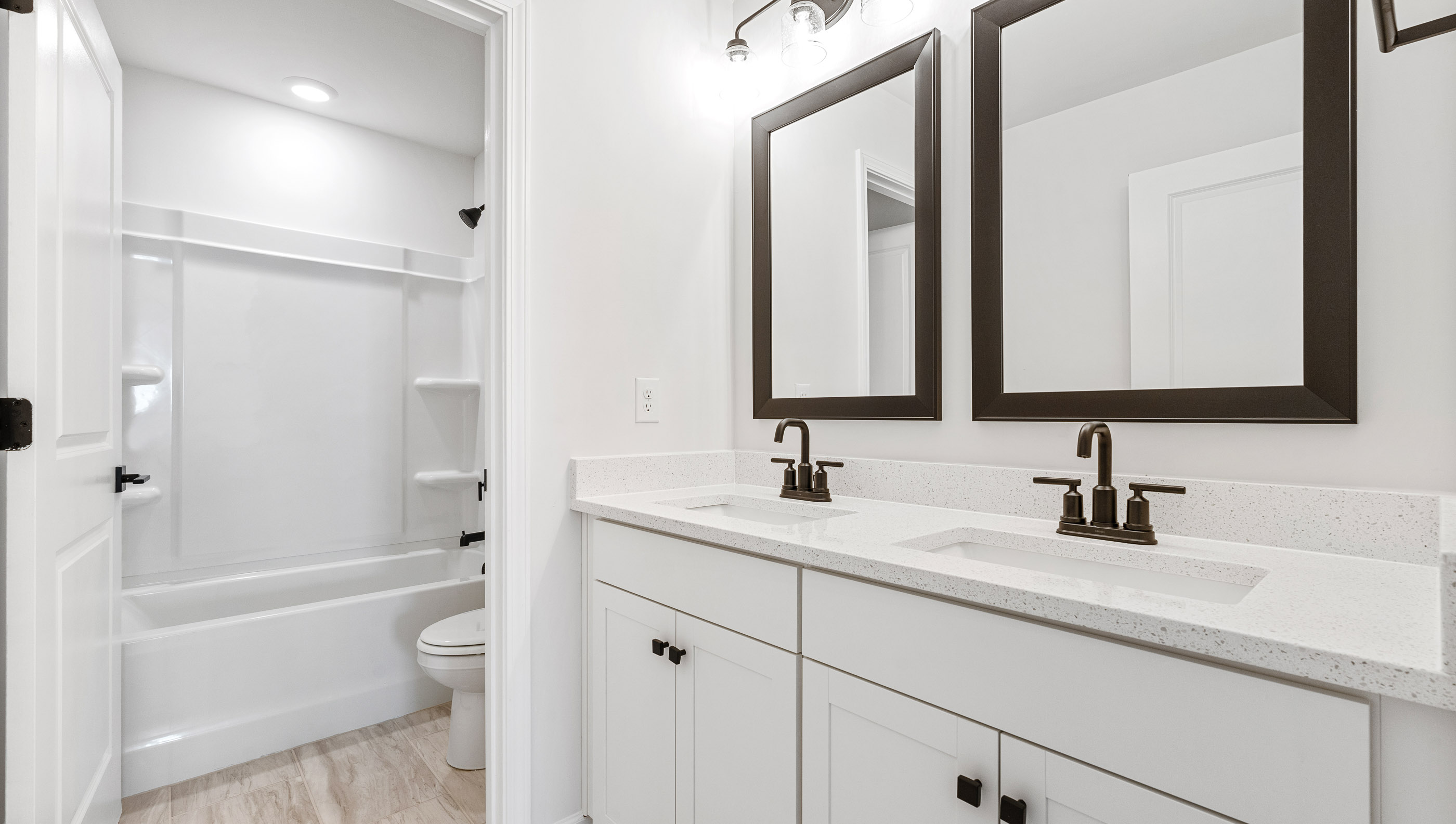 Hall bathroom with dual sink vanity and shower/tub.