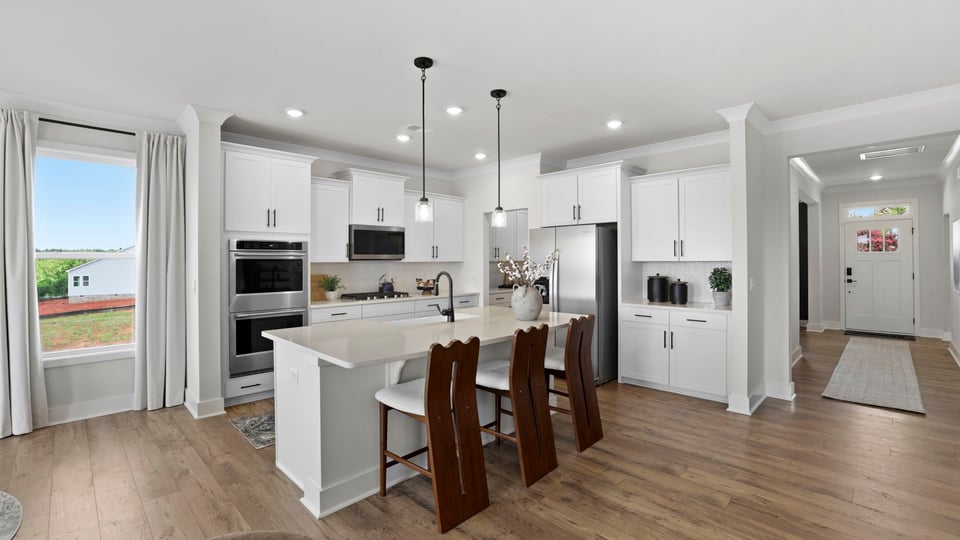 Kitchen and island with quartz countertops and stainless steel appliances.
