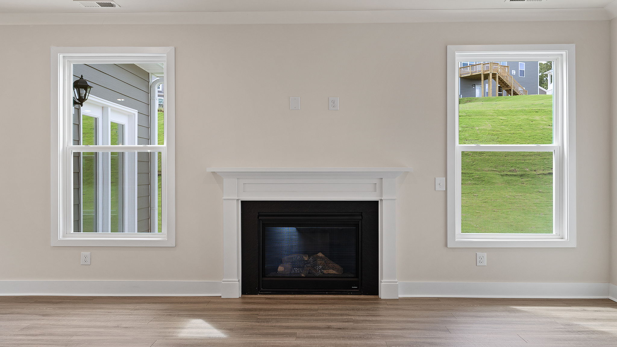 Gas log fireplace accented by two windows.