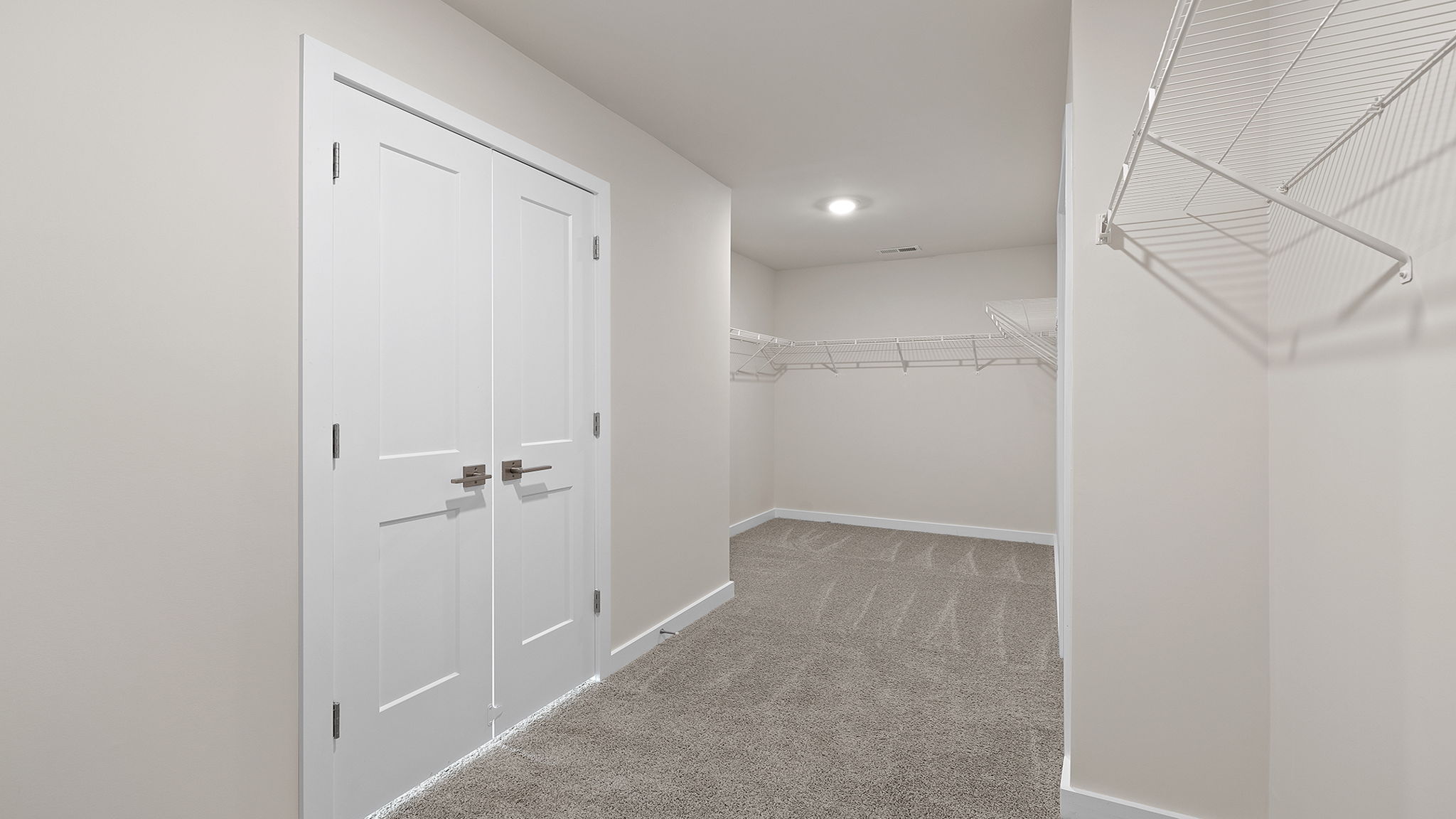 View of primary bedroom closet with his and hers closet hanging areas.