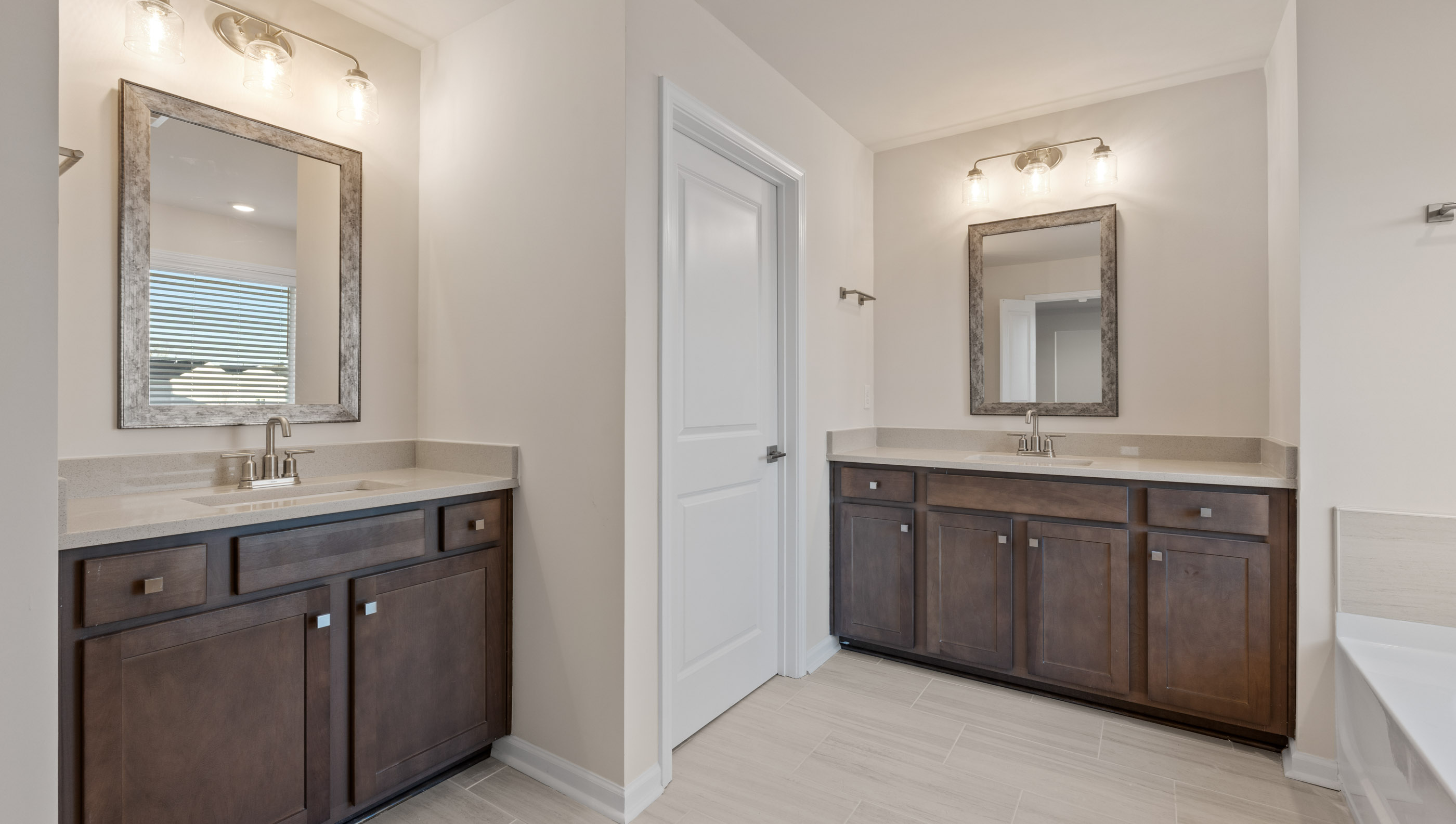 Primary bathroom with his and her vanities.