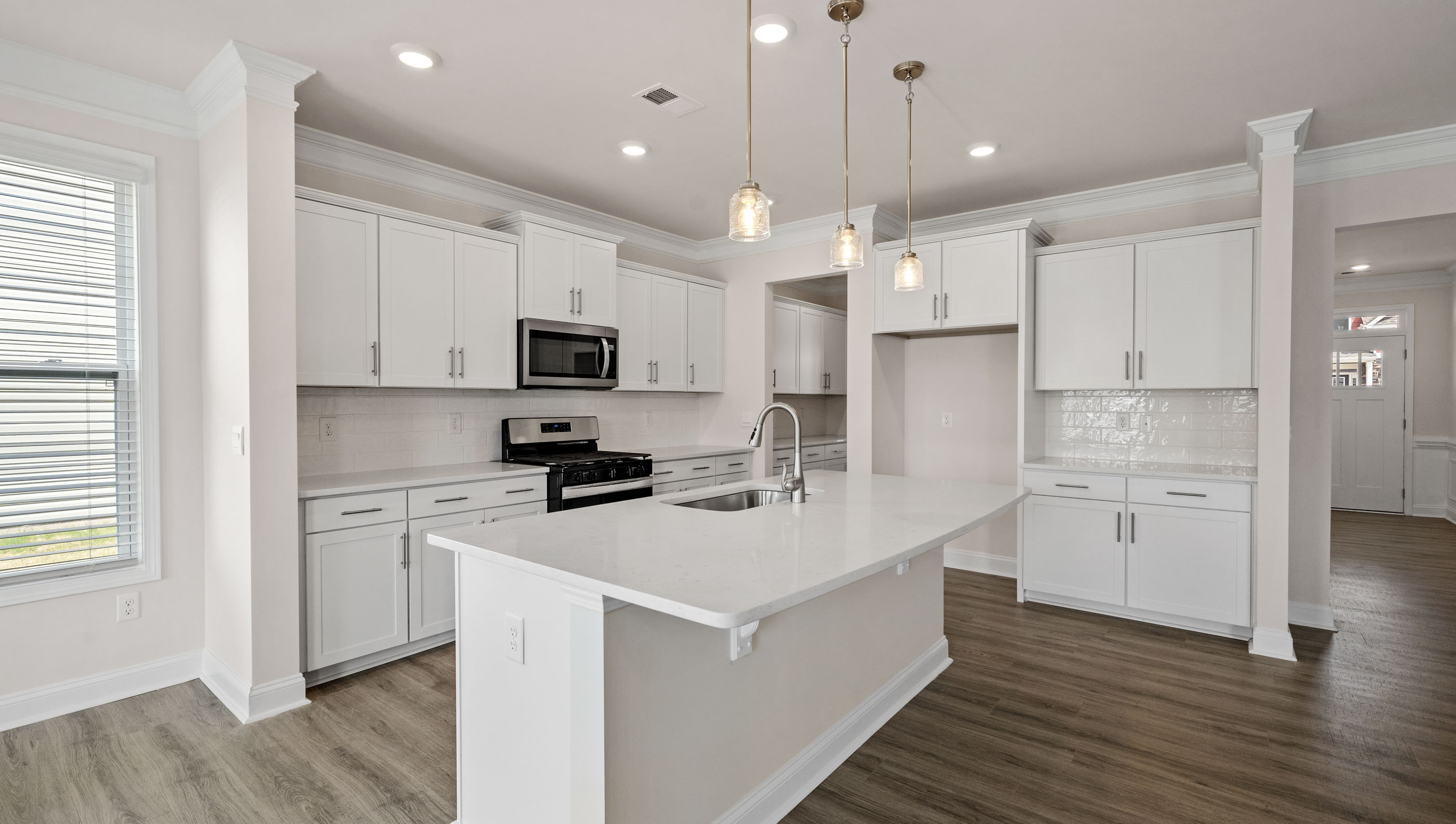 Kitchen with island and pendulum lights.