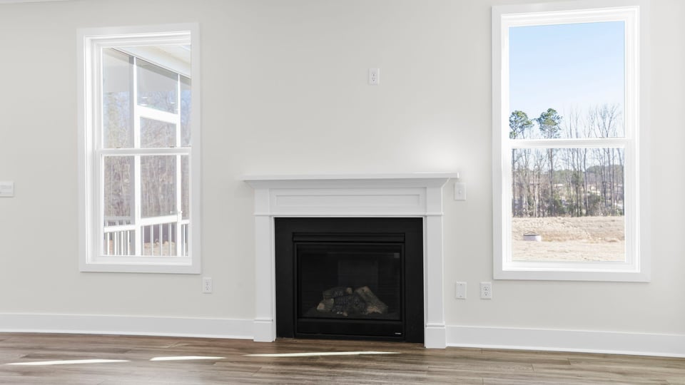 Fireplace accented by two large windows.