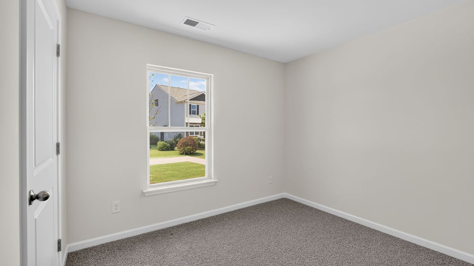 Bedroom with carpet and window.