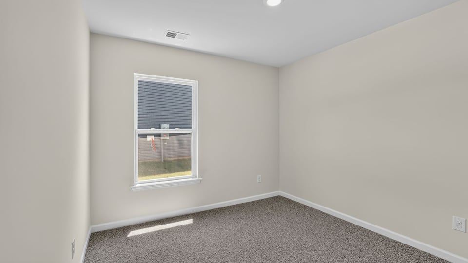 Bedroom with carpet and window.