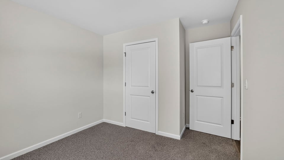 Bedroom with carpet and window.