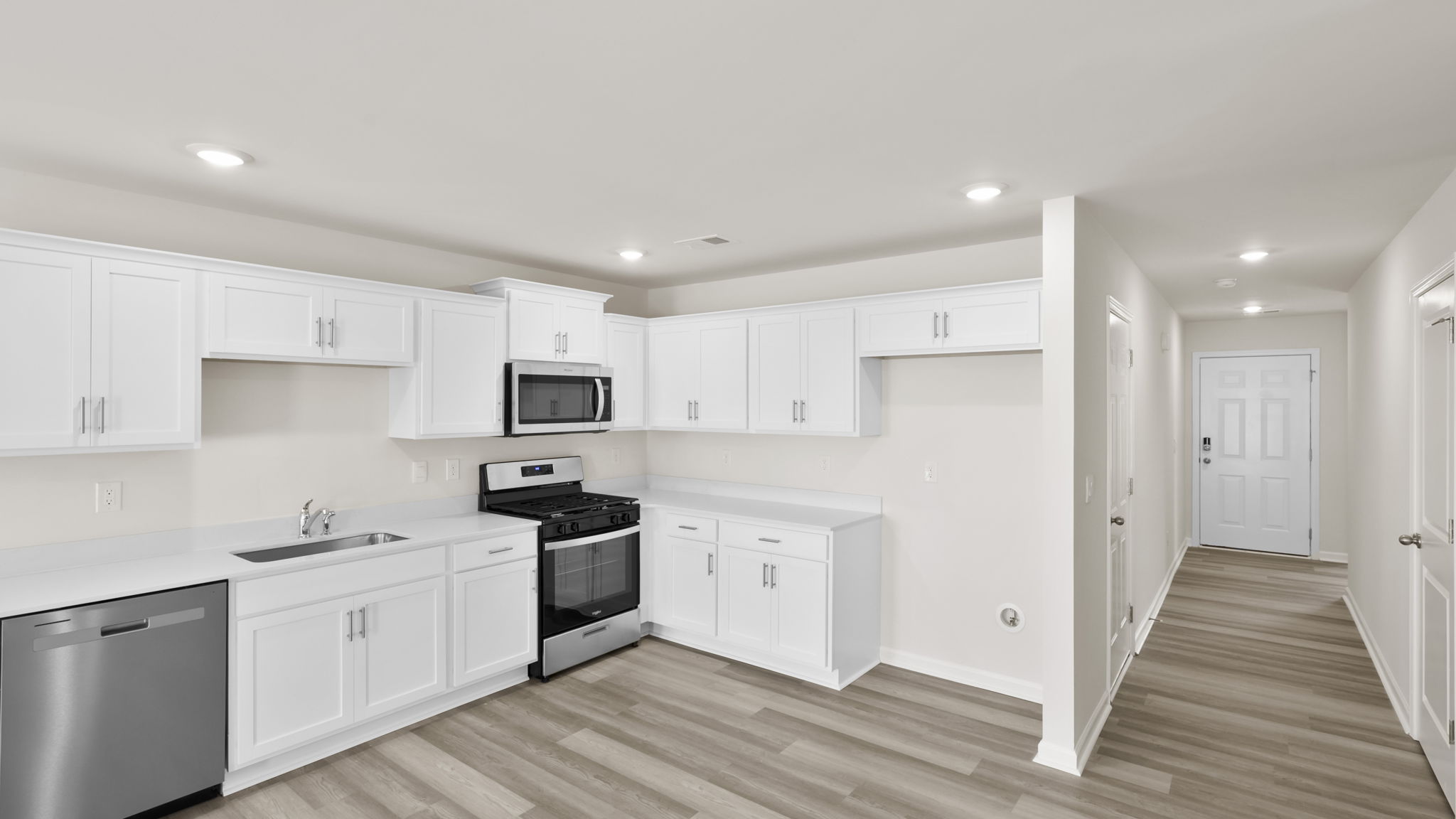 Kitchen with quartz countertops and stainless steel applainces.