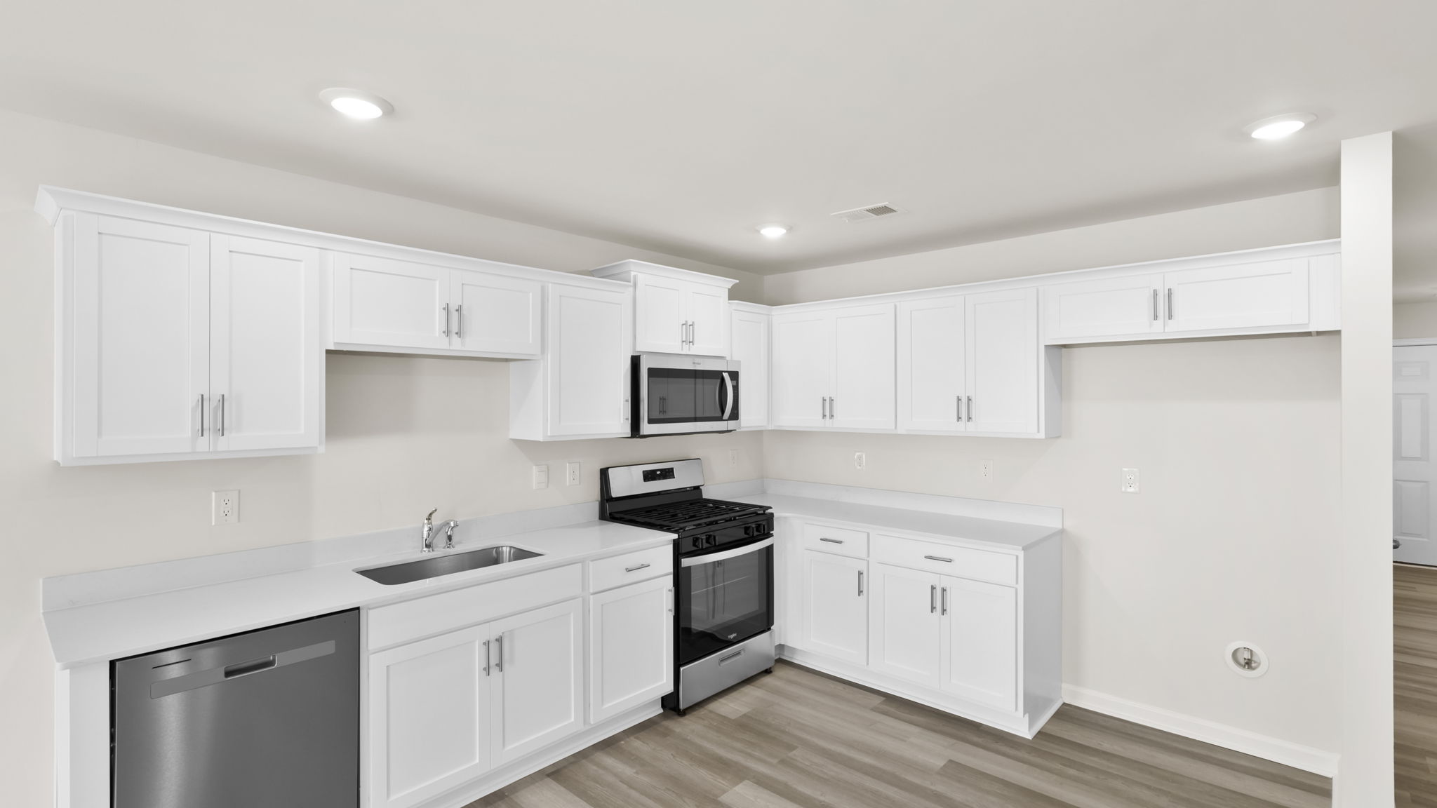 Kitchen with quartz countertops and stainless steel applainces.