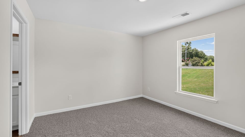 Bedroom with carpet and window.