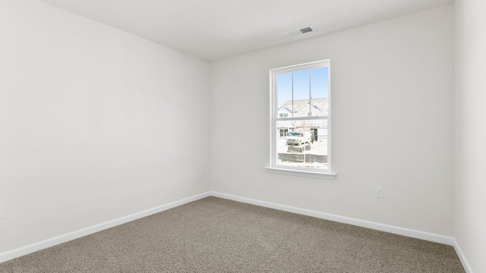 Bedroom with carpet and window.