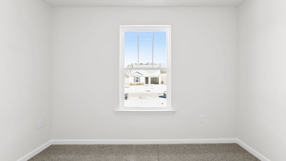 Bedroom with carpet and window.