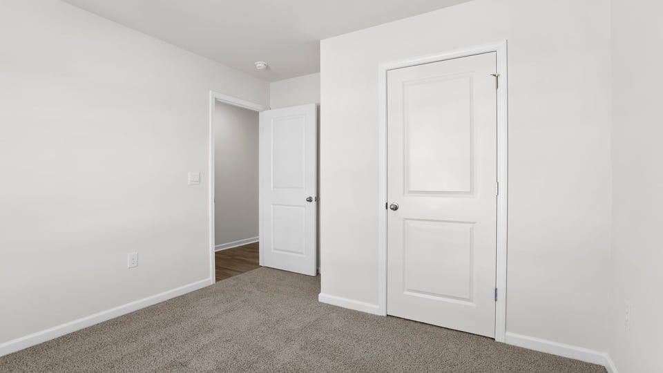 Bedroom with carpet and window.