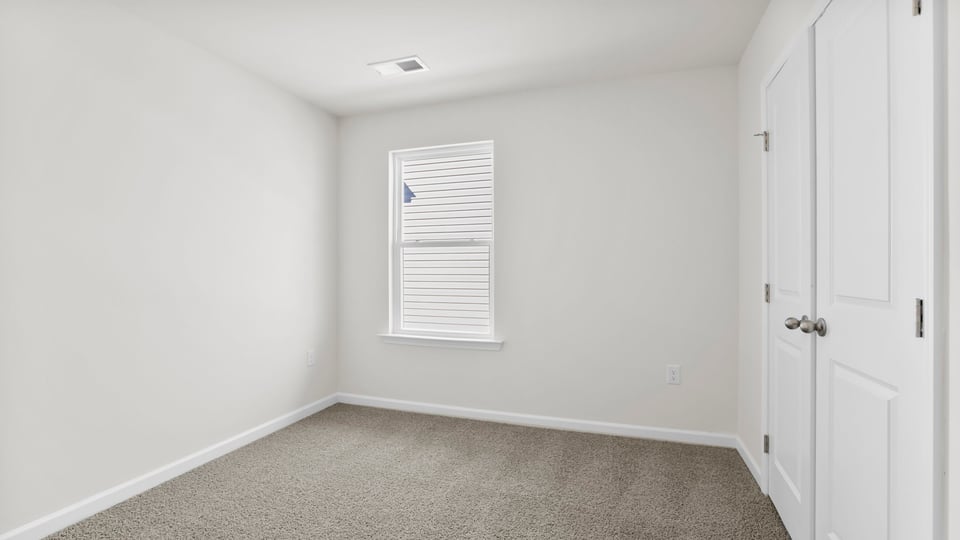 Bedroom with carpet and window.