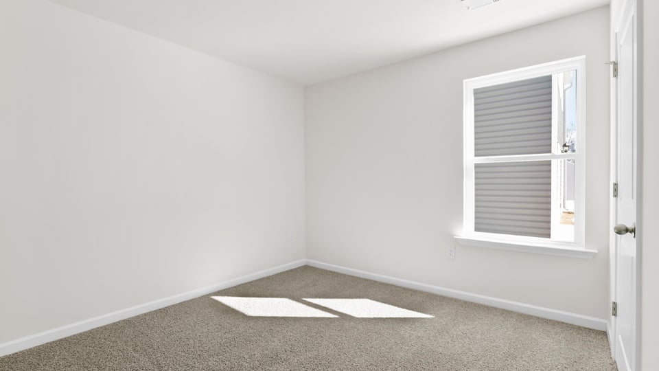 Bedroom with carpet and window.