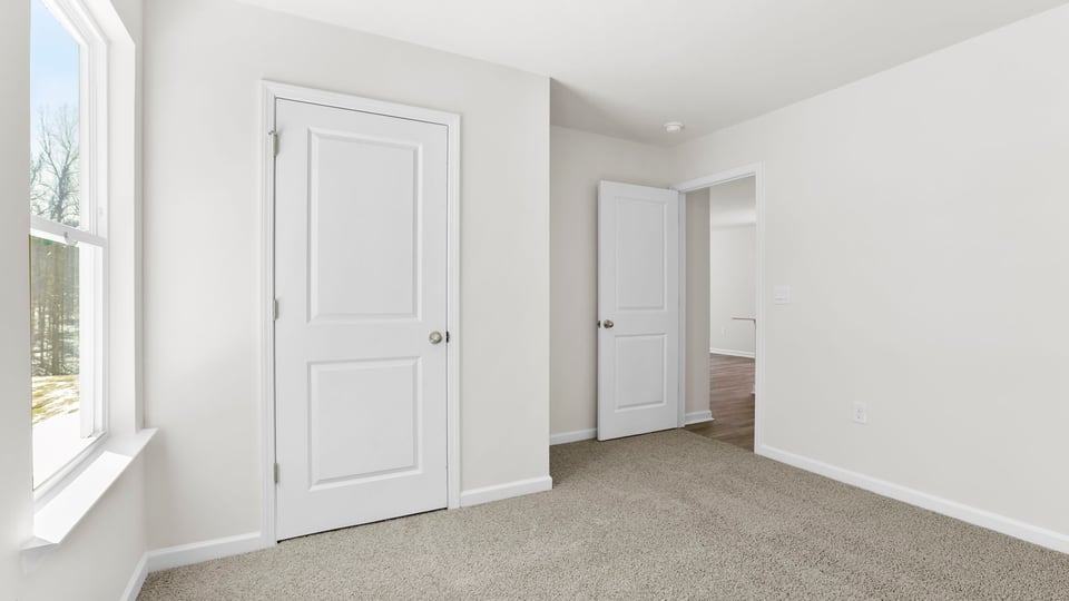 Bedroom with carpet and window.