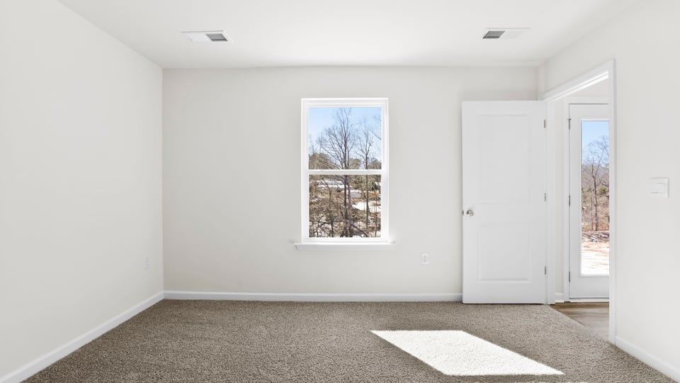 Bedroom with carpet and window.