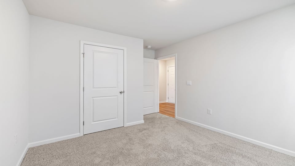 Bedroom with carpet and window.