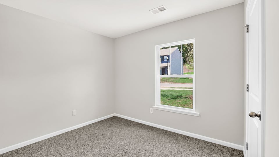 Bedroom with carpet and windows.