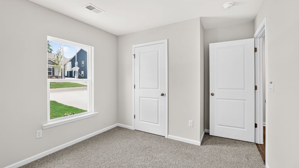 Bedroom with carpet and windows.